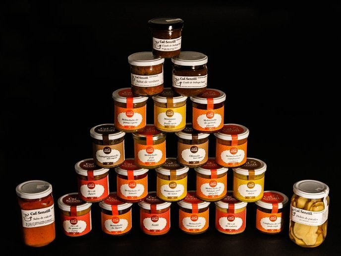 Piràmide de pots de conserves artesanes de Cal Senzill sobre fons fosc